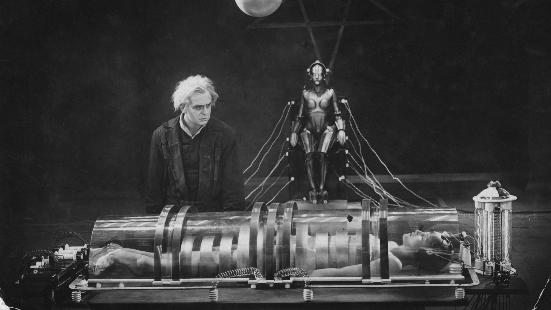 Film still from 'Metropolis'. A mad scientist looks over his robot/human hybrid creation in his underground laboratory.
