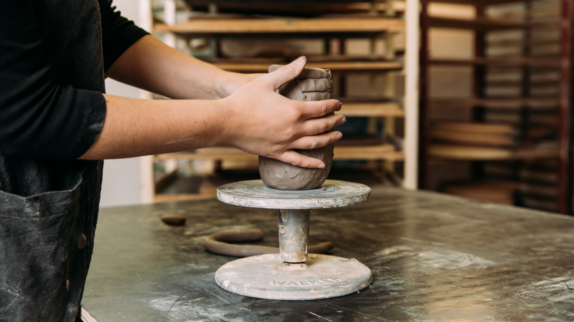 Photo of a JamFactory ceramic artist hand-building a cup