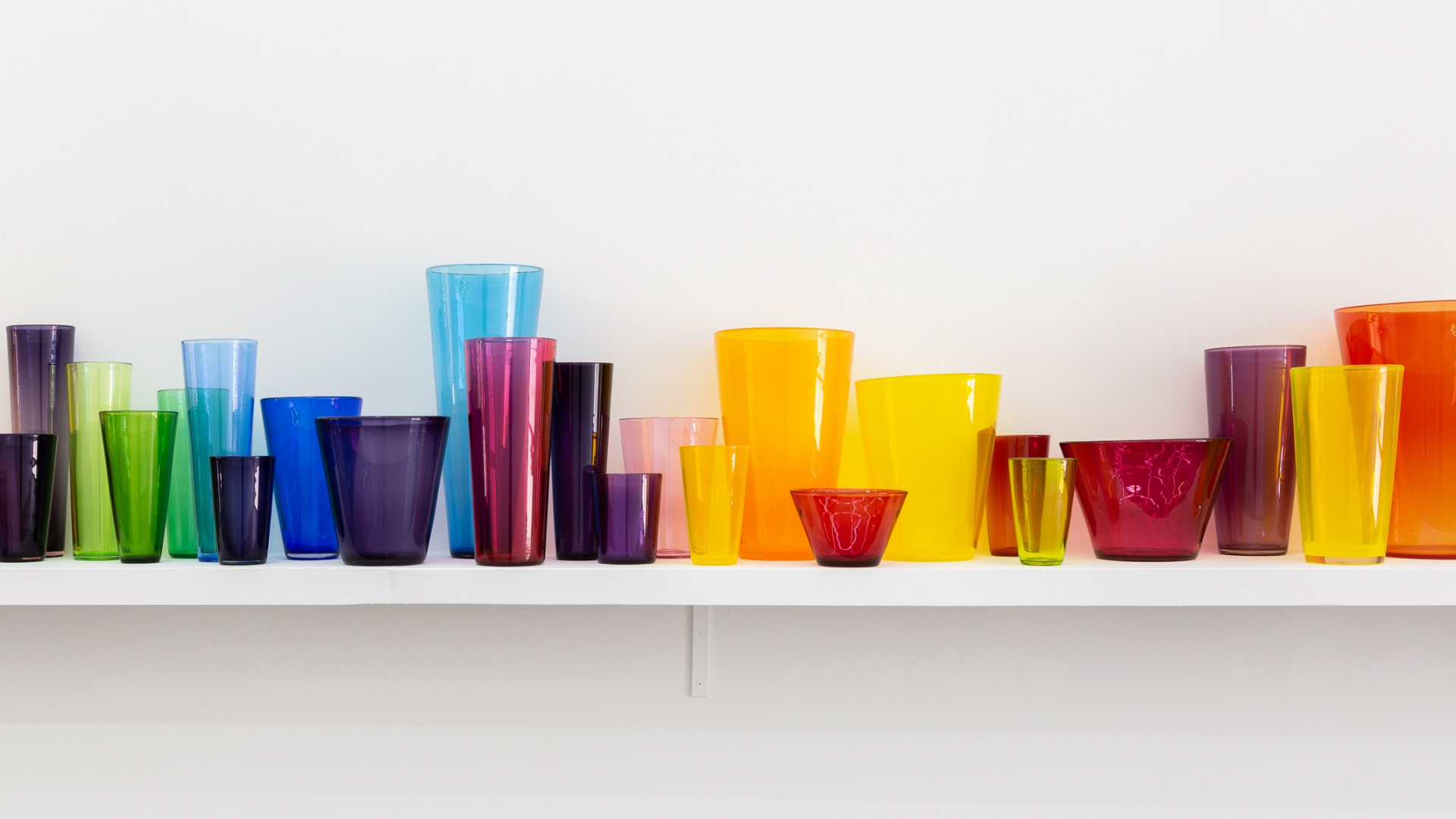 A colourful assemblage of glass beakers, vases and bowls 
