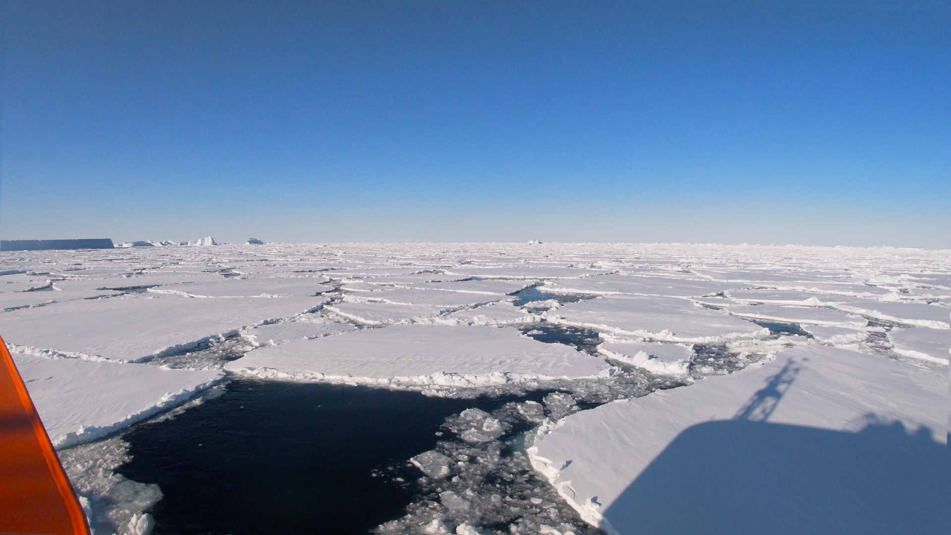 A view of Antarctic ice sheets on a blue sky day