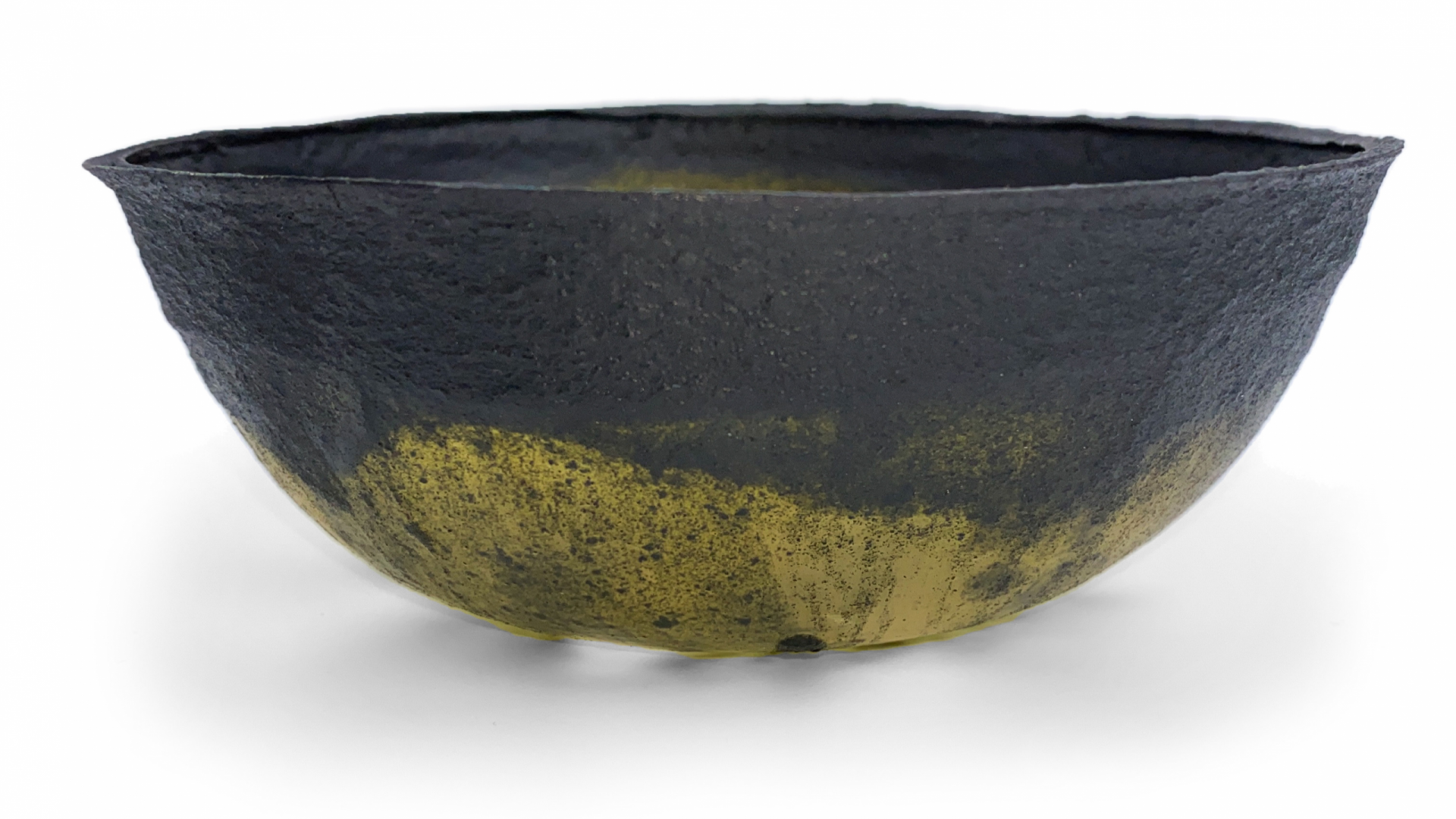 Photo from side of dark green and transparent bioplactic bowl made with red algae polymer, plant-based plasticiser and spirulina microalgae pigment.